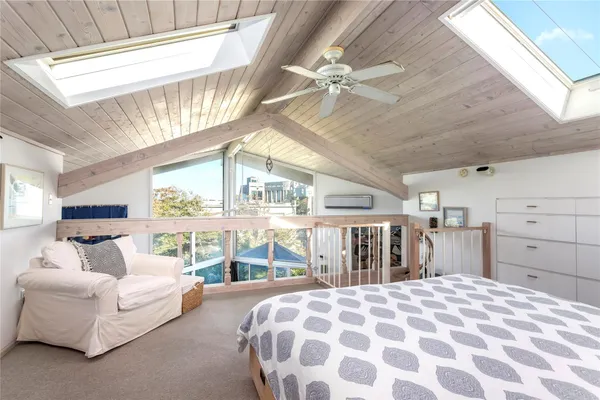 a spacious bedroom with a large bed and a chandelier