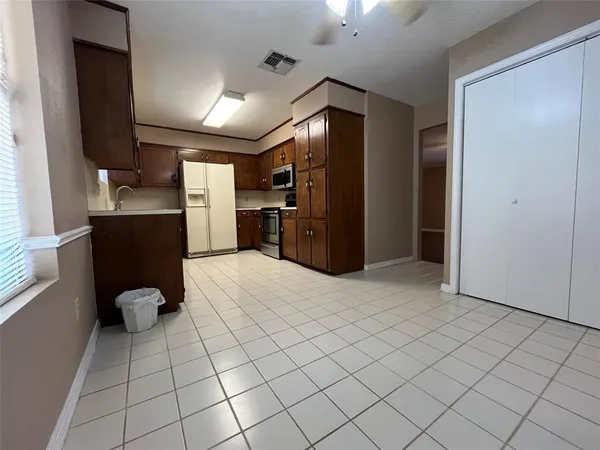 a kitchen with granite countertop a refrigerator and a stove top oven