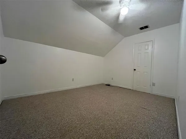 en empty room with ceiling fan and window