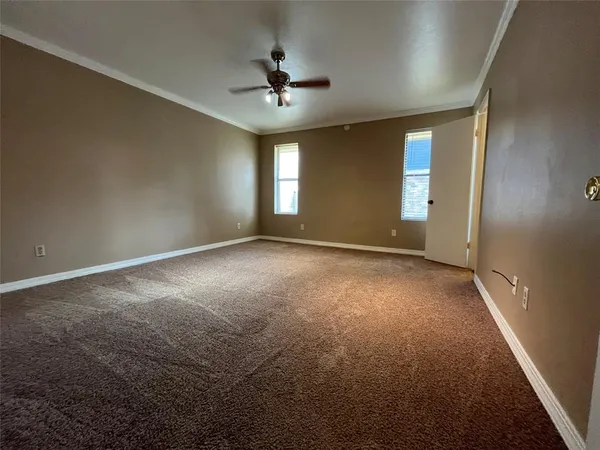 an empty room with windows and fan