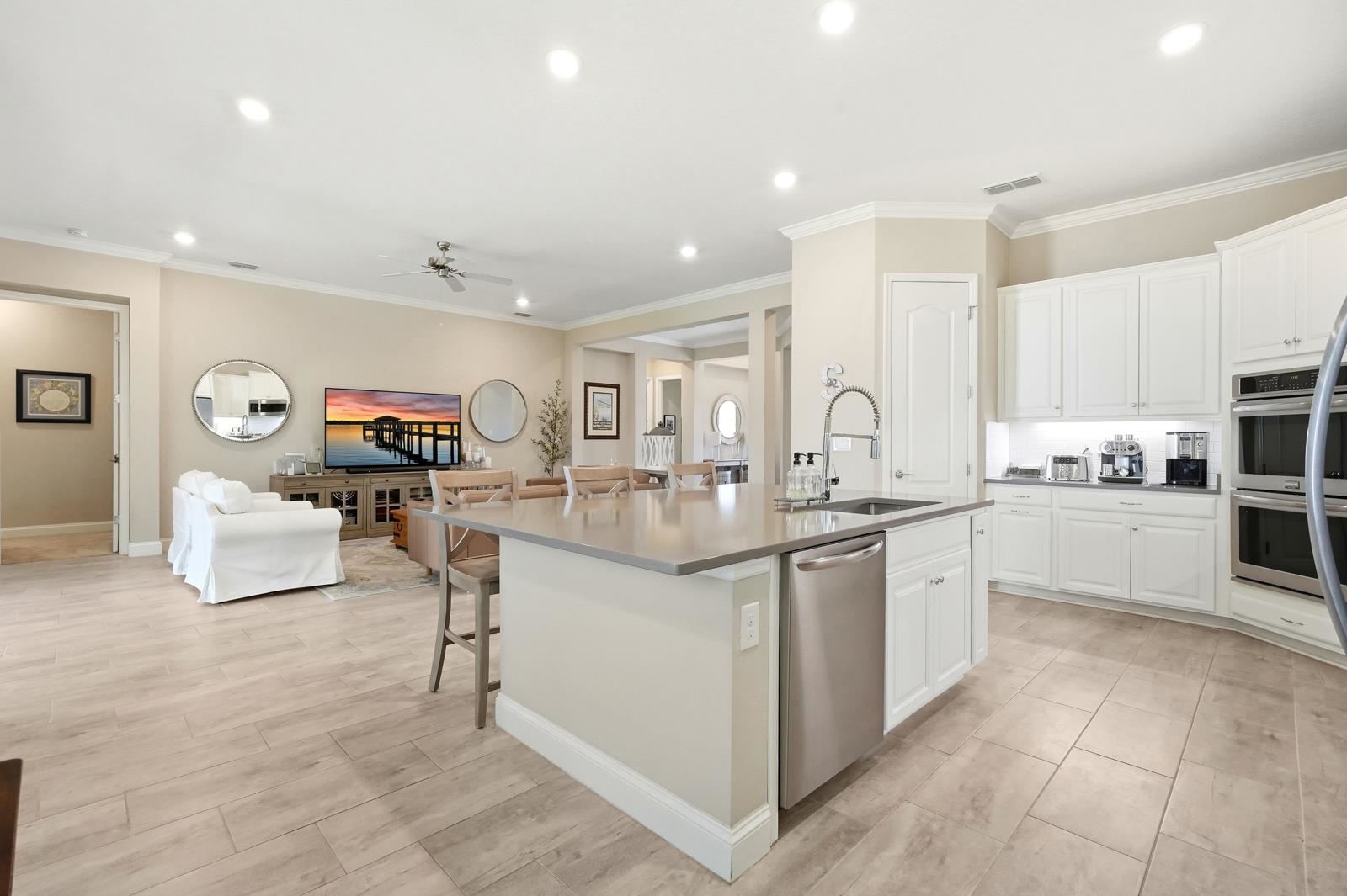 170 Antolin Way St. Augustine, FL 32095 - Photo 20 of 85 Kitchen featuring a breakfast bar, white cabinets, crown molding, a center island with sink, and appliances with stainless steel finishes
