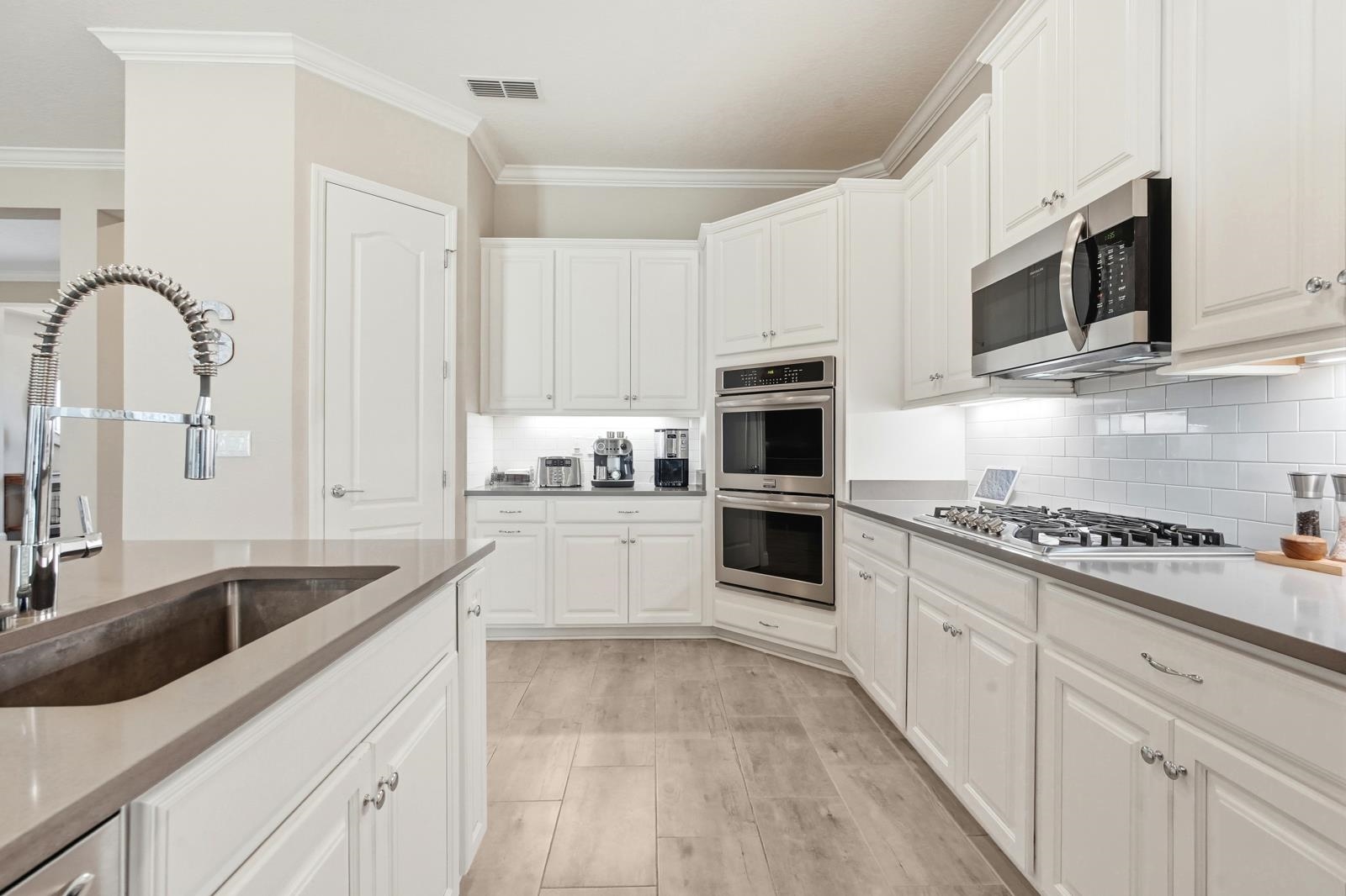 170 Antolin Way St. Augustine, FL 32095 - Photo 22 of 85 a kitchen with granite countertop white cabinets a sink a stove and oven with wooden floor