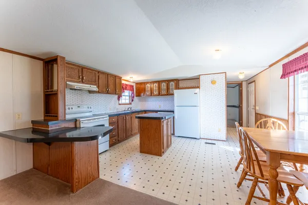 a kitchen with granite countertop a sink stove and cabinets