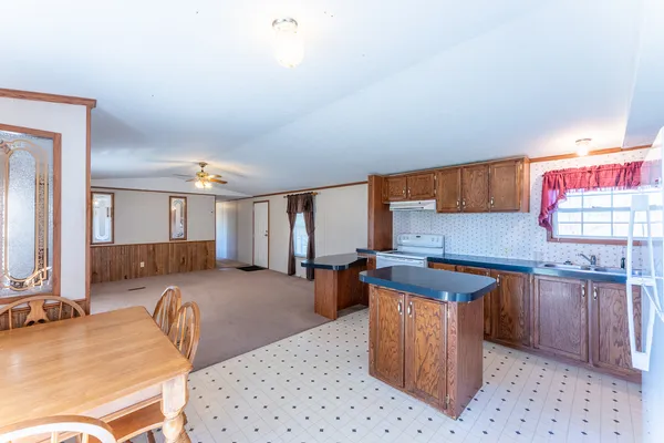 a kitchen with stainless steel appliances granite countertop a sink a stove and a microwave