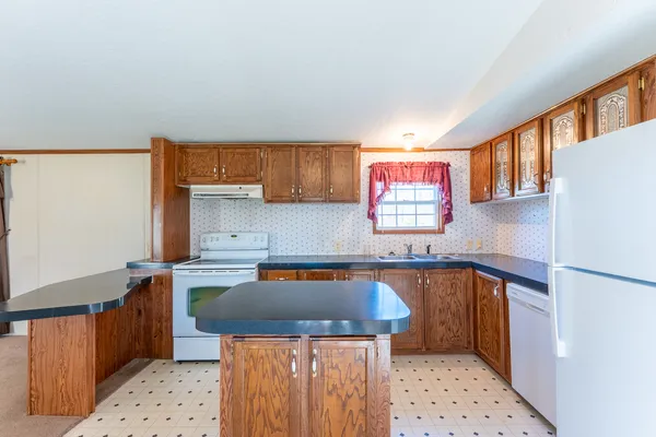 a kitchen with stainless steel appliances granite countertop a table chairs and a refrigerator