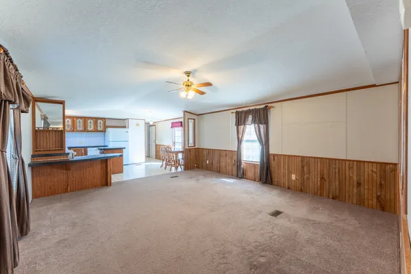 a kitchen with stainless steel appliances kitchen island granite countertop a table chairs in it and wooden floors