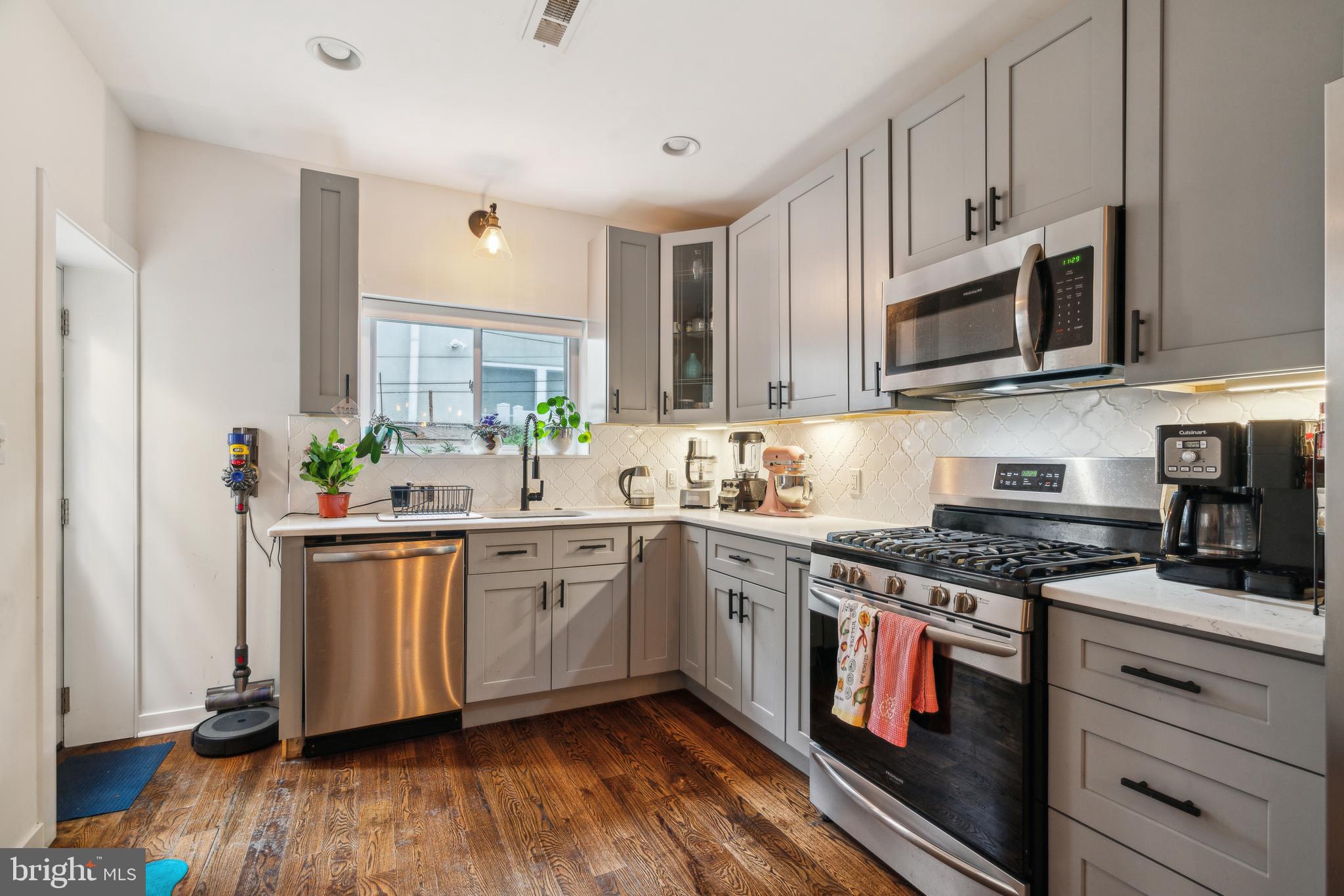 1319 Tasker Street Philadelphia, PA 19148 - Photo 7 of 23 a kitchen with stainless steel appliances granite countertop a stove a sink and a microwave