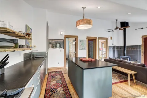 a kitchen with stainless steel appliances granite countertop a stove and a sink with wooden floor