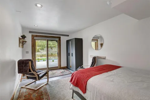 a bedroom with a bed a chair and a large window