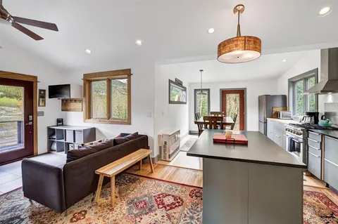 a living room with furniture kitchen view and a large window