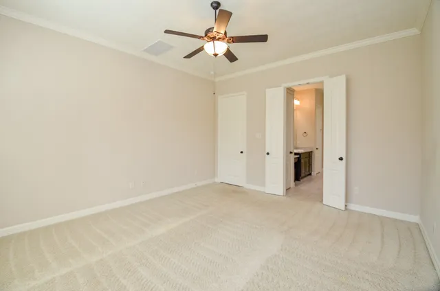 an empty room with closet and a chandelier fan