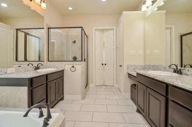a spacious bathroom with a shower sink and mirror