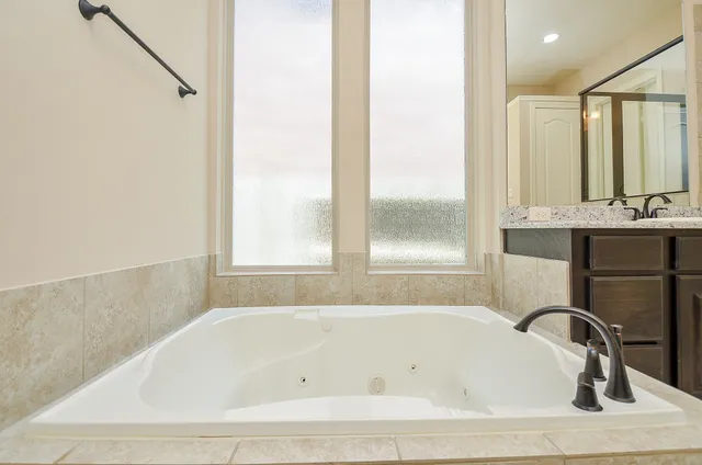 a white bath tub sitting in a bathroom next to a window