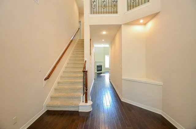 a view of a hallway with wooden floor and staircase