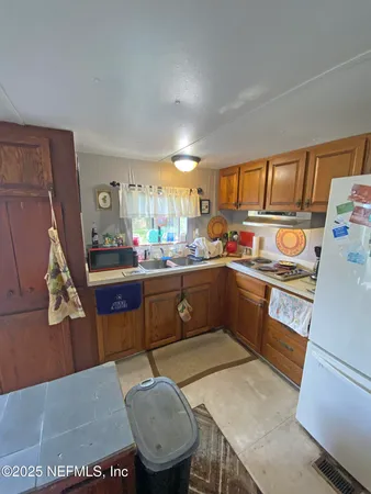 a kitchen with a sink a stove cabinets and a dining table