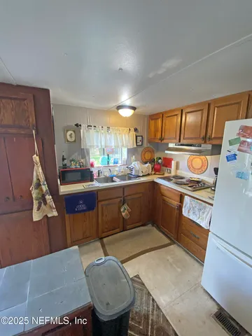 a kitchen with a sink a stove cabinets and a dining table