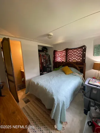 a bedroom with a bed and a mirror
