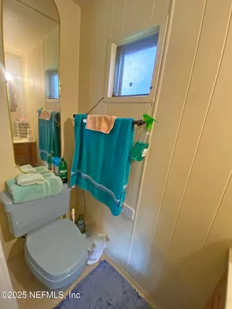 a bathroom with a toilet and a mirror