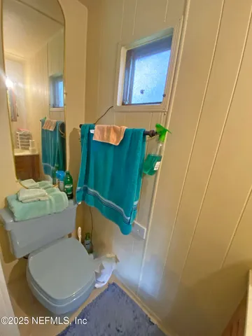 a bathroom with a toilet and a mirror