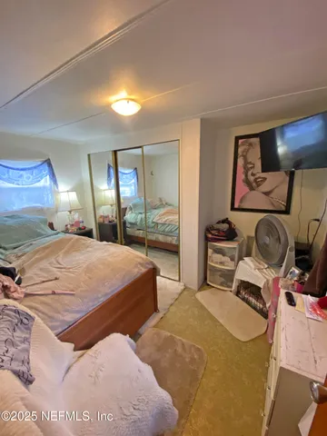 a bedroom with a bed and large mirror