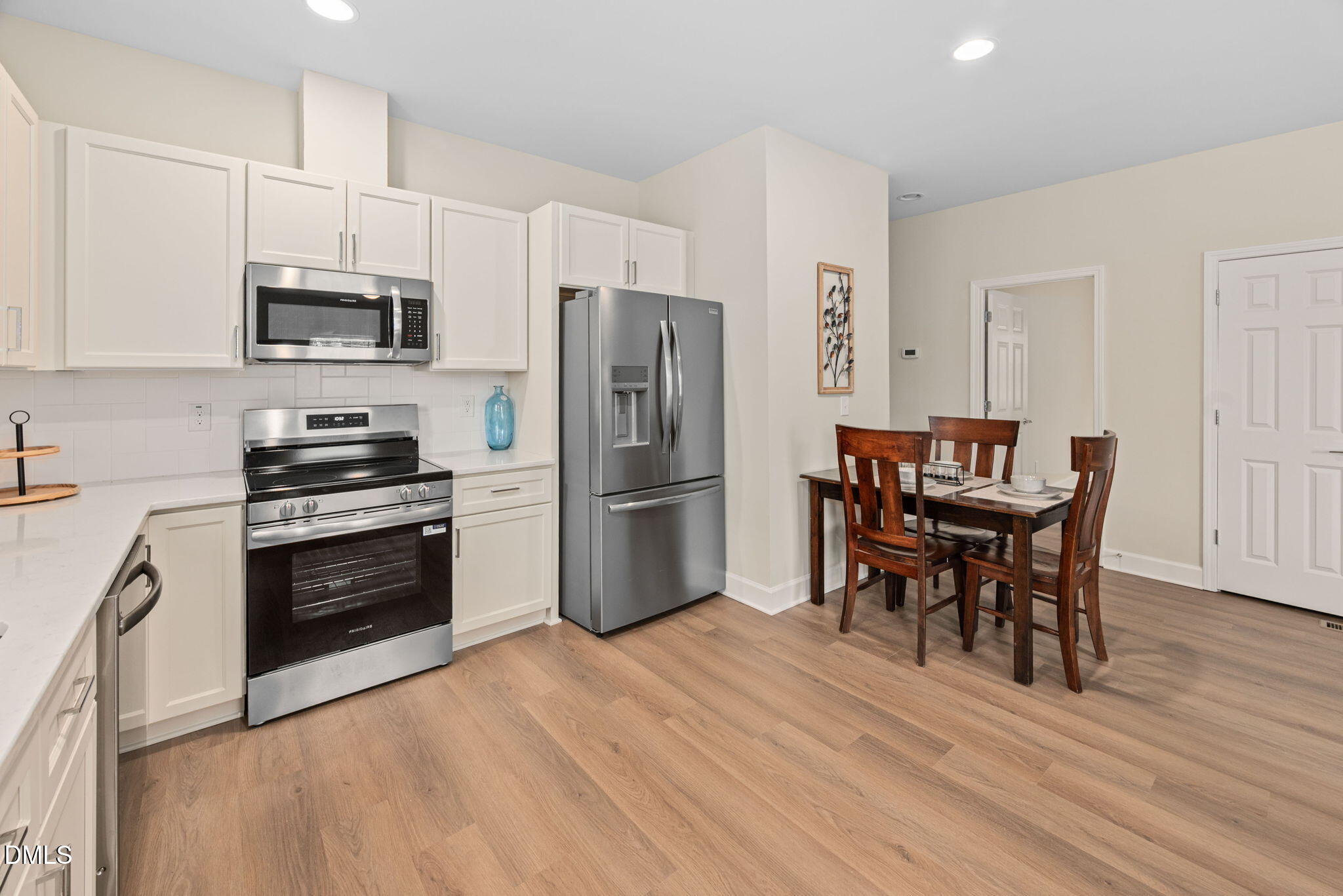 1106 South Blount Street Raleigh, NC 27601 - Photo 7 of 33 a kitchen with granite countertop a refrigerator stove microwave and cabinets with wooden floor