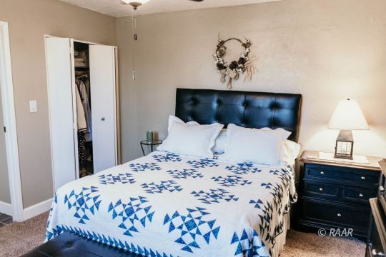 428 Peg Street Ridgecrest, CA 93555 - Photo 18 of 29 a bedroom with a bed and a lamp on table