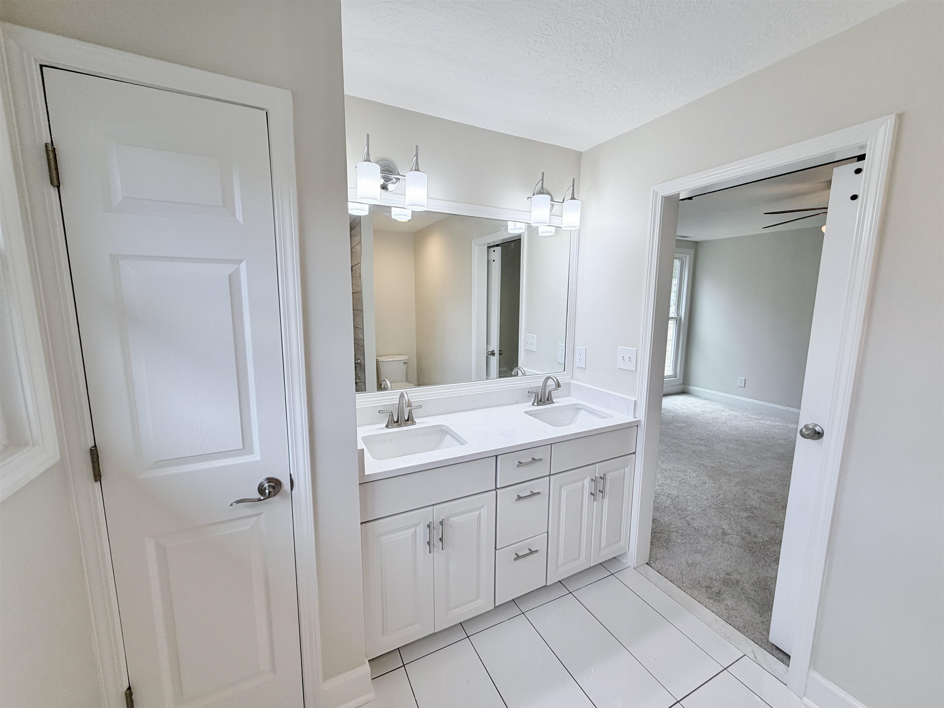 955 Country Club Road Somerville, TN 38068 - Photo 27 of 40 Full bath featuring light colored carpet, double vanity, light tile patterned floors, a textured ceiling, and ceiling fan