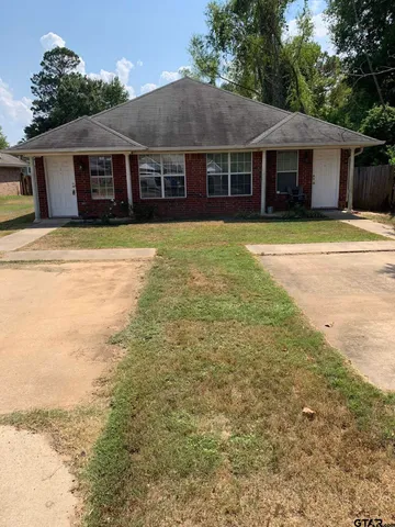 a view of a house with a garden and trees