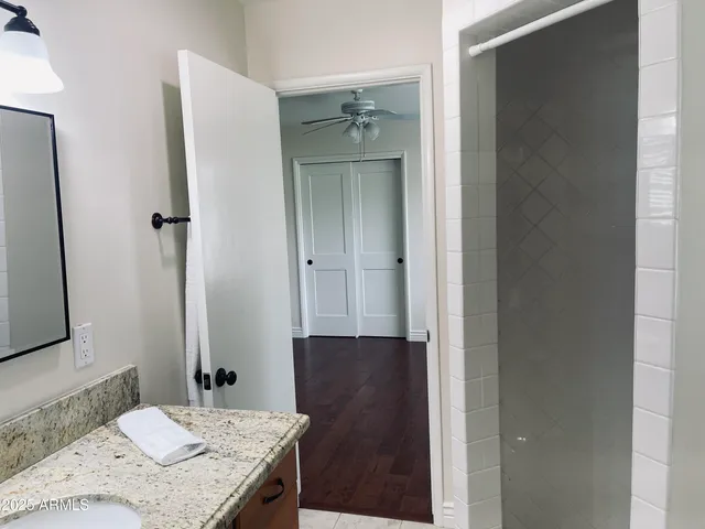 a bathroom with a granite countertop sink and a mirror