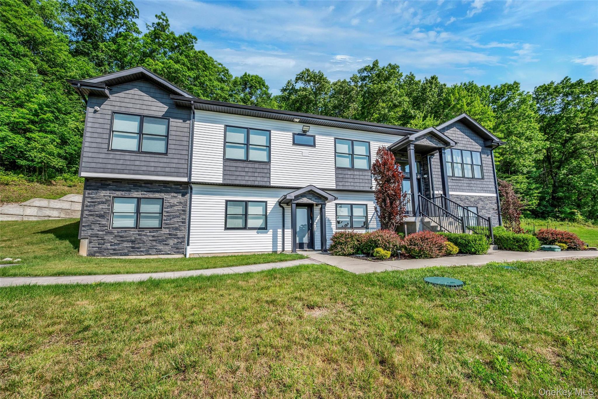 31 Walnut Ridge Lane Bloomingburg, NY 12721 - Photo 3 of 50 a front view of a house with a garden and trees