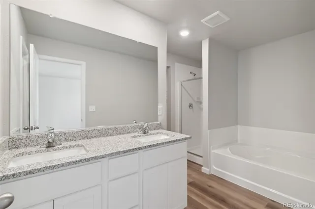 a bathroom with a granite countertop bathtub sink double and mirror