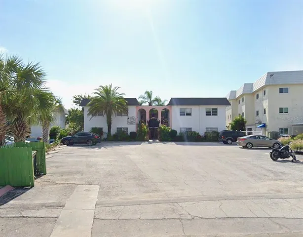 a view of a house with outdoor space and palm trees