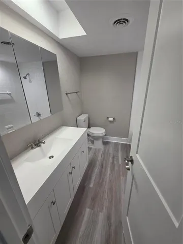 a bathroom with a sink a toilet and a mirror