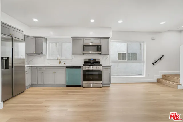 a kitchen with a refrigerator and a stove top oven
