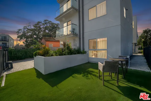a view of a patio with table and chairs potted plants with wooden floor and fence