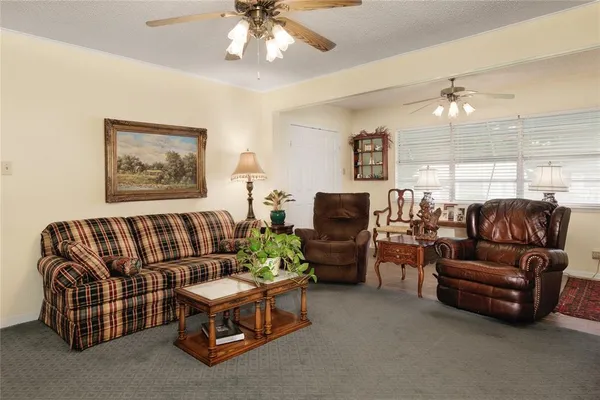 a living room with furniture a ceiling fan and a window