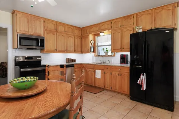 a kitchen with stainless steel appliances granite countertop a refrigerator and a stove top oven