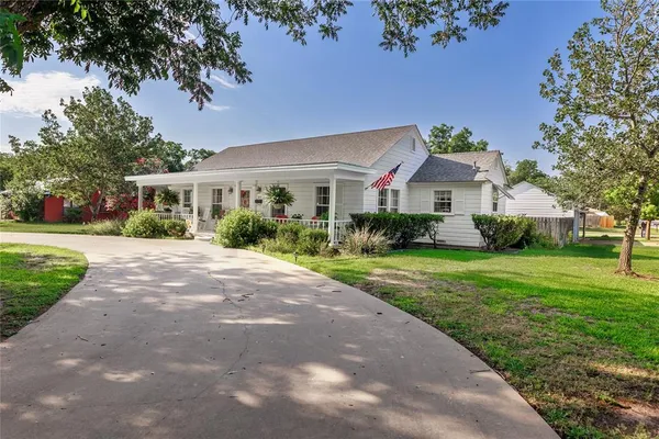 a front view of a house with a yard and potted plants