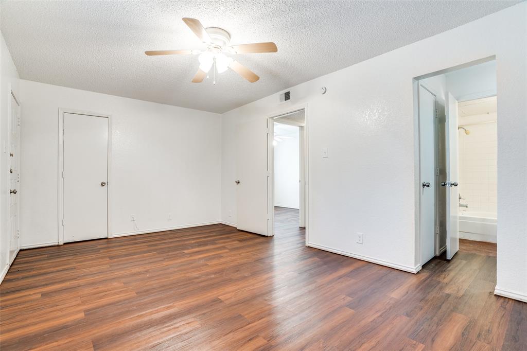 2820 Ridgecrest Drive Fort Worth, TX 76133 - Photo 14 of 25 Unfurnished bedroom with wood finished floors, a textured ceiling, ceiling fan, ensuite bath, and visible vents