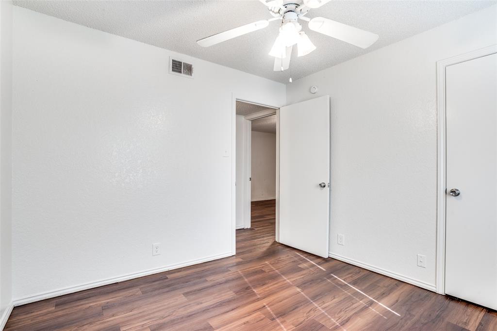 2820 Ridgecrest Drive Fort Worth, TX 76133 - Photo 21 of 25 Unfurnished bedroom featuring a textured ceiling, baseboards, visible vents, wood finished floors, and ceiling fan