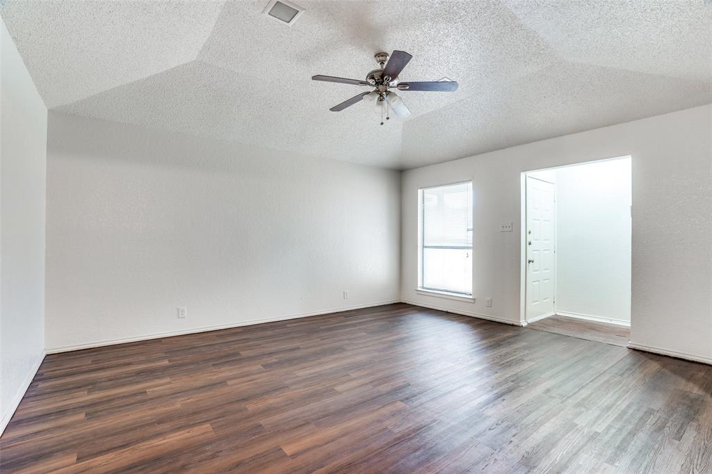 2820 Ridgecrest Drive Fort Worth, TX 76133 - Photo 6 of 25 Unfurnished room with visible vents, a ceiling fan, dark wood-style floors, and a textured ceiling