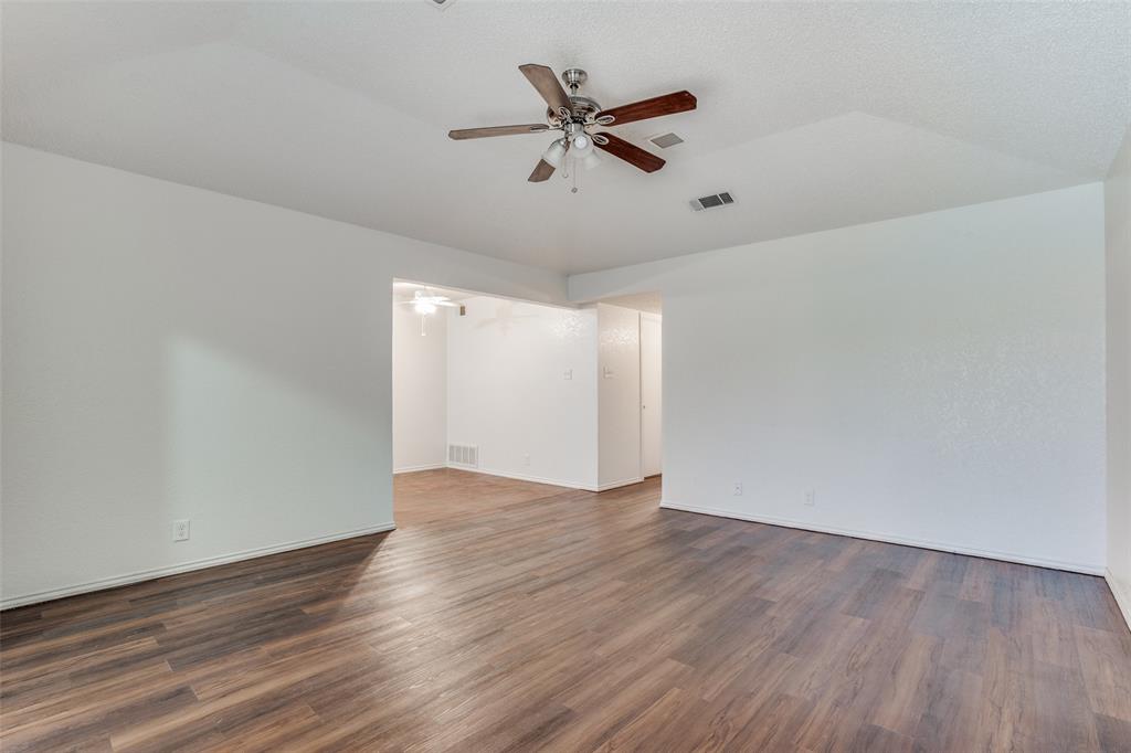 2820 Ridgecrest Drive Fort Worth, TX 76133 - Photo 8 of 25 Empty room with vaulted ceiling, wood finished floors, visible vents, and ceiling fan