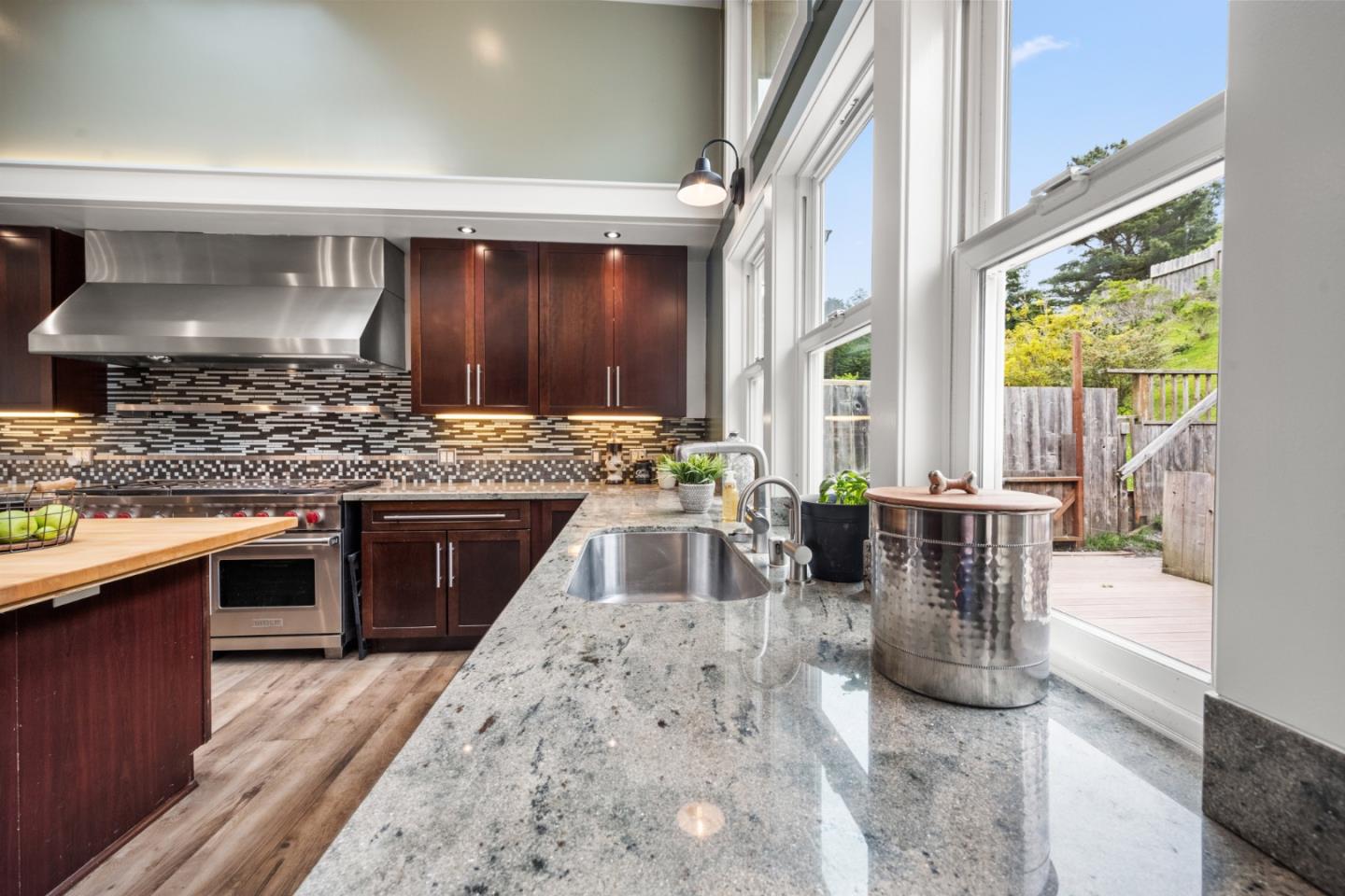970 Park Pacifica Avenue Pacifica, CA 94044 - Photo 15 of 61 a kitchen with stainless steel appliances granite countertop a stove a sink and a wooden cabinets