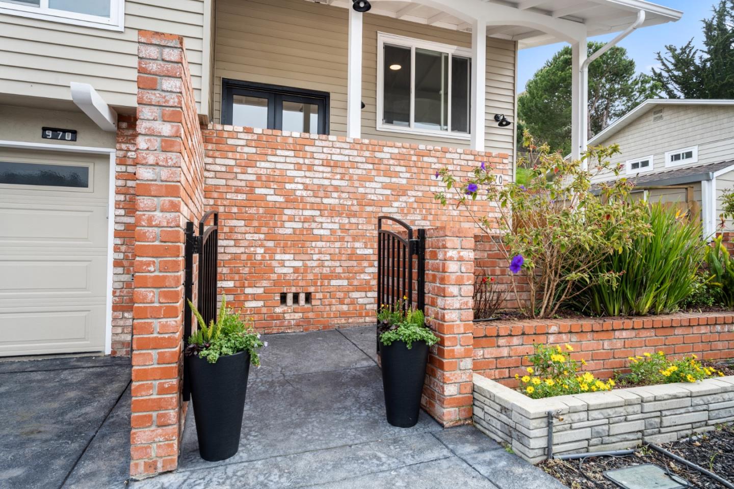 970 Park Pacifica Avenue Pacifica, CA 94044 - Photo 2 of 61 a front view of a house with lots of potted plants
