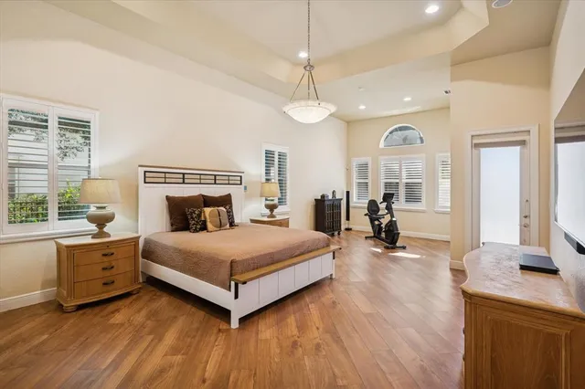 a bedroom with a bed chandelier and dresser