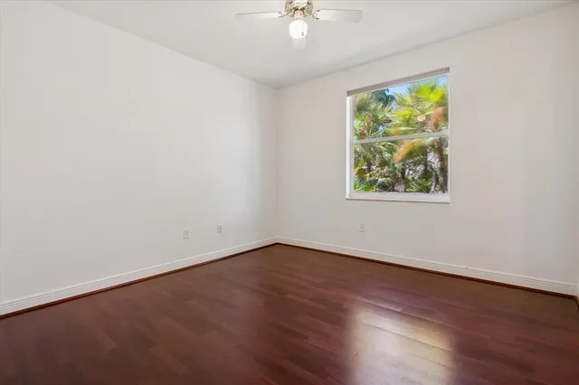 an empty room with wooden floor and window