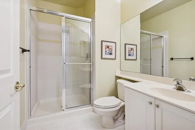 a bathroom with a shower sink vanity mirror and toilet
