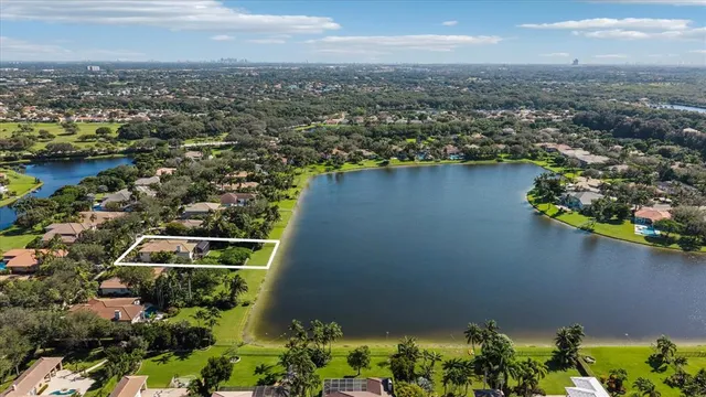 an aerial view of residential houses with outdoor space and lake view