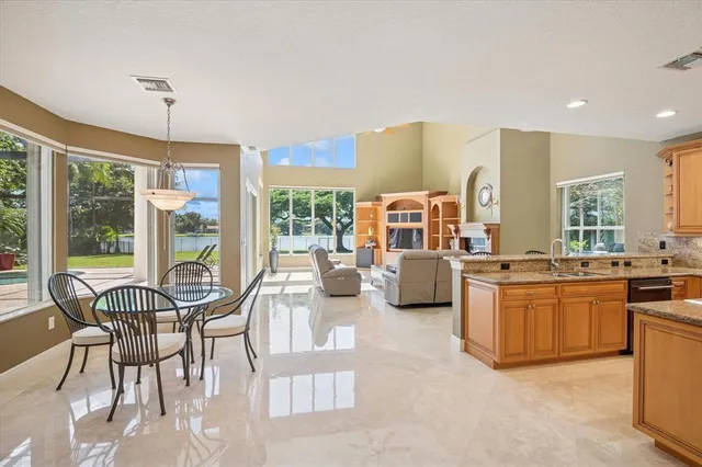 a living room with furniture a flat screen tv and large windows