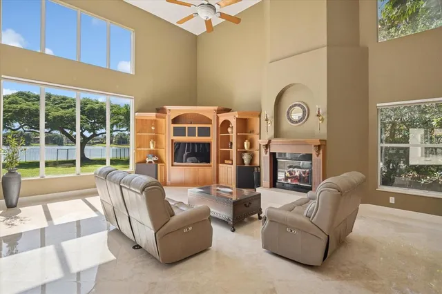 a living room with furniture a fireplace and a floor to ceiling window